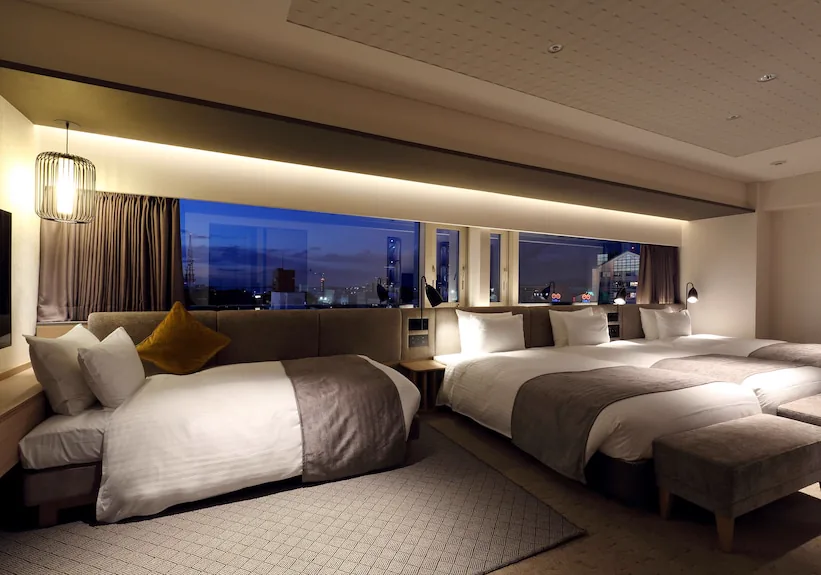 Solaria Nishitetsu Hotel Fukuoka Deluxe Quad สำหรับผู้ใหญ่ 4 คน มีพื้นที่ใช้ร่วมกันและเตียงที่จัดวางอย่างกว้างขวาง