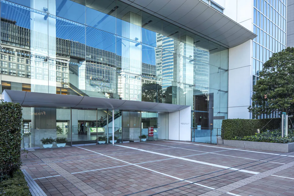 ทางเข้าโรงแรม Century Southern Tower เป็นกระจกบานใหญ่และเส้นทางเดินเท้า