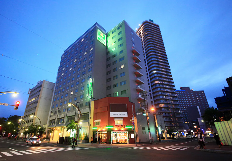 ภาพด้านหน้าของ Vessel Inn Sapporo Nakajima Park เหมาะสำหรับเปรียบเทียบเส้นทางเดินจากโรงแรมไปยังสถานี Nakajima Park สำหรับครอบครัวที่มีเด็กเล็ก