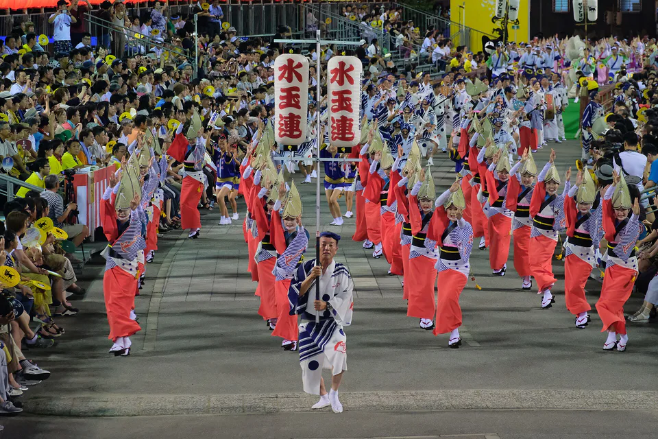 นักเต้นและผู้ชมในสนามแสดง Awa Odori แบบมีที่นั่งของโทคุชิมะยามค่ำคืน